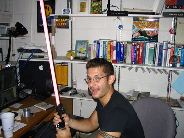Vasilios Hoffman sitting in his office, holding a lightsaber